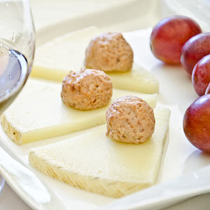 Cuñas de queso manchego semicurado Las Terceras D.O.P. con bolitas de crema de jamón ibérico y uvas negras