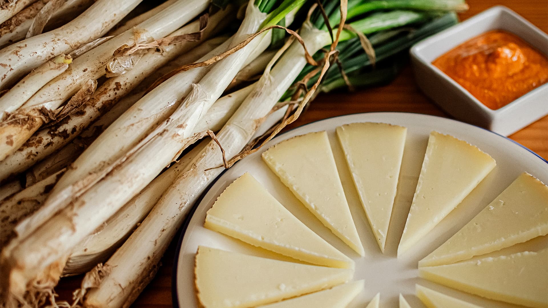 Manchego cheese with calçots and romesco sauce